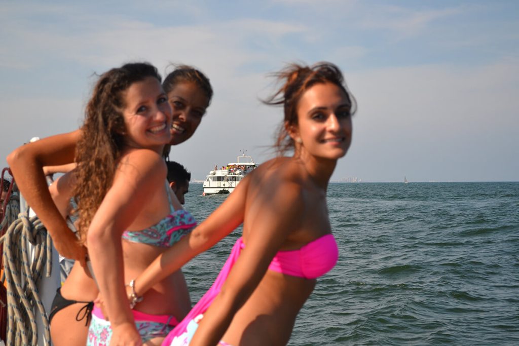 Fiesta en barco al atardecer en Valencia con música y copa