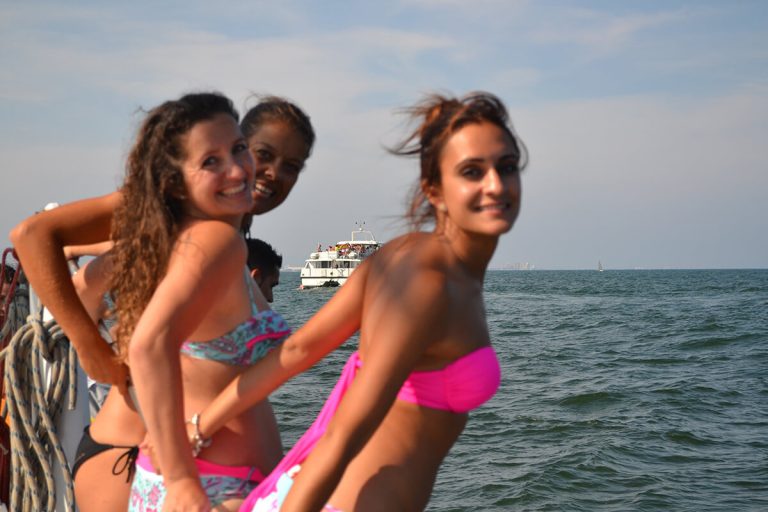 Fiesta en barco al atardecer en Valencia con música y copa