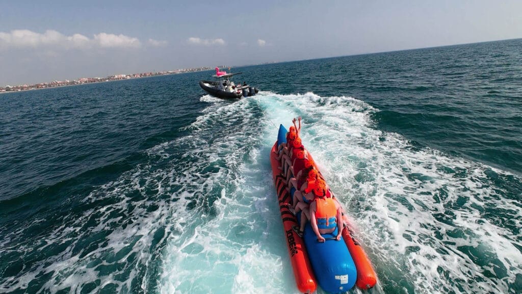 Grupo de 8 personas disfrutando de una banana boat frente a la playa de la Malvarrosa, Valencia