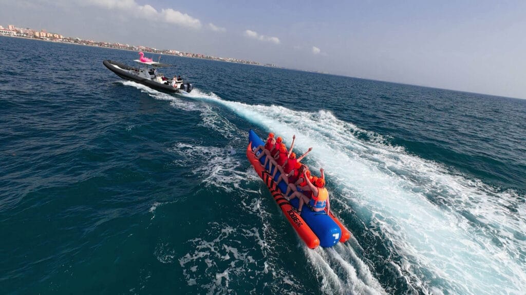 Grupo de 8 personas disfrutando de una banana boat frente a la playa de la Malvarrosa, Valencia