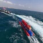 Grupo de 8 personas disfrutando de una banana boat frente a la playa de la Malvarrosa, Valencia