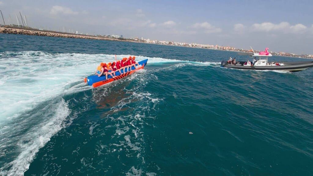 Grupo de 8 personas disfrutando de una banana boat frente a la playa de la Malvarrosa, Valencia