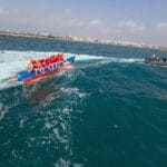 Grupo de 8 personas disfrutando de una banana boat frente a la playa de la Malvarrosa, Valencia