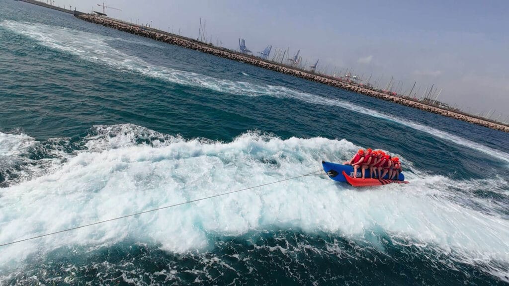 Grupo de 8 personas disfrutando de una banana boat frente a la playa de la Malvarrosa, Valencia